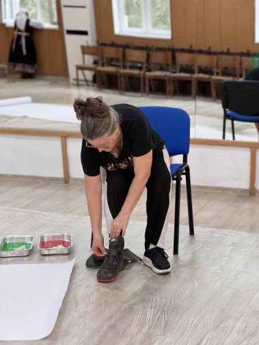 Денка Георгиева от Народно читалище "Св. Св. Кирил и Методий - 1927" с.Тополи оставя отпечатъци от стъпките на 8 типични народни хора от село Тополи - подготовка за работа